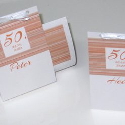 Großartige Geburtstagsmenükarte in Form einer Schriftrolle bedruckt mit Linienmotiv in orange.