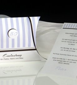 Geburtstagseinladung als Schriftrolle mit einer passenden Verpackung.