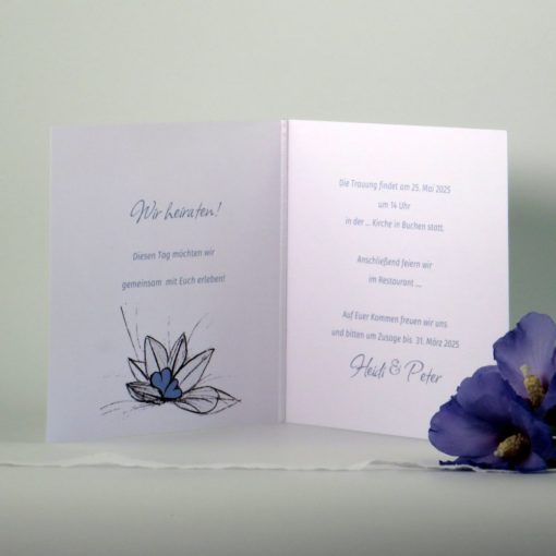 Hochzeitseinladung mit blauen Herzen im Blätternest.