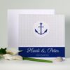 Dekorative Hochzeitseinladung in maritimen Style mit einem Anker als Hingucker.