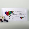 Hochzeitseinladung mit Herzmotiv in Regenbogenfarben auf weiß.